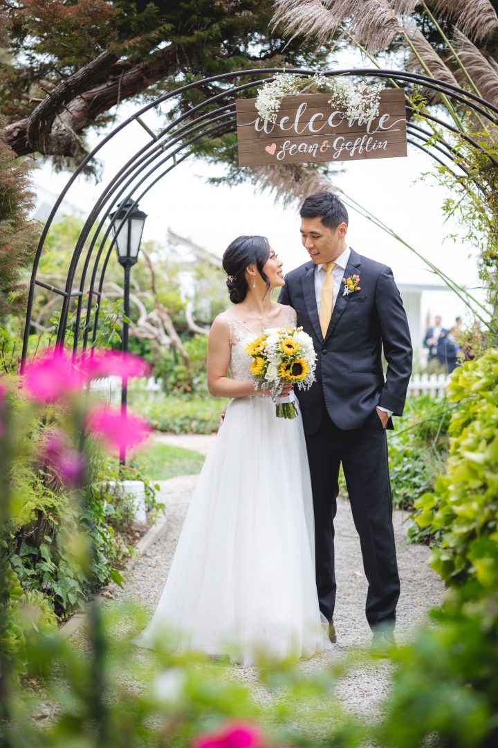 wedding couple posing under sign